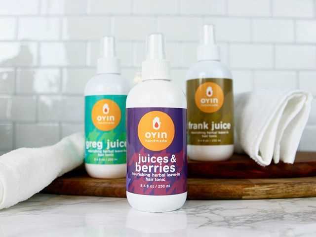 Oyin Juices & Berries nourishing herbal leave-in hair tonic on a countertop with juice bottles and towel.